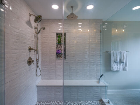 Walk-in shower with built-in seating and stylish tile work.