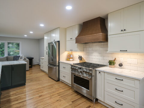 Kitchen range with a wood range hood, stainless steel oven, and ample cabinet space.