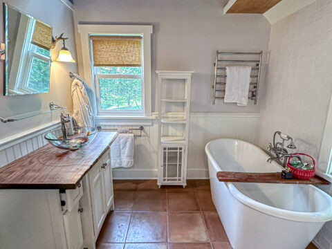 Completed bathroom with bathtub, rustic beams, and elegant fixtures.
