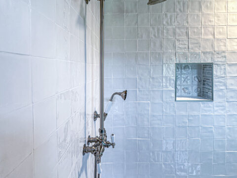 shower wall with unique tile design and handheld showerhead.