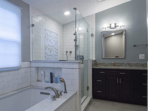 Modern bathroom with bathtub, glass shower, and vanity.