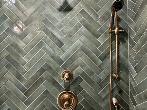 Brushed Brass Dual Shower System on Herringbone Tile Wall