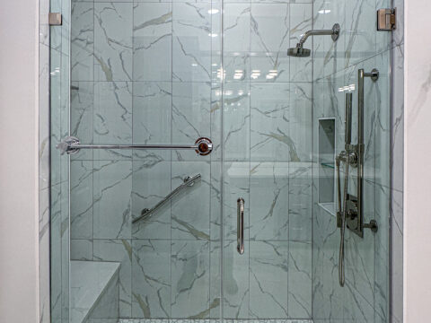 Frameless Glass Shower with Marble-Effect Tile and Hexagon Mosaic Floor