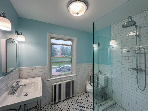 Light Blue Bathroom Remodel with Glass Shower and Patterned Floor Tile