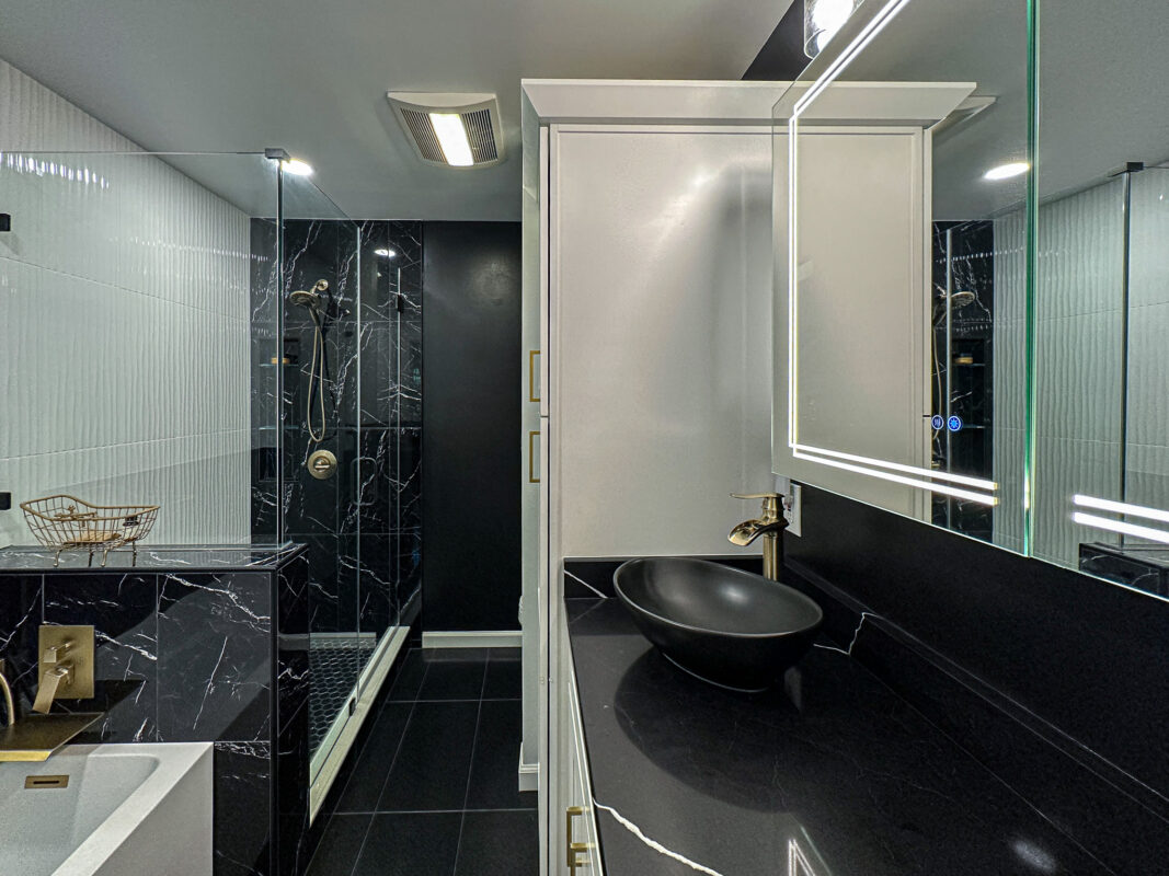 Luxury Bathroom Renovation with Black Quartz Countertops and Gold Hardware