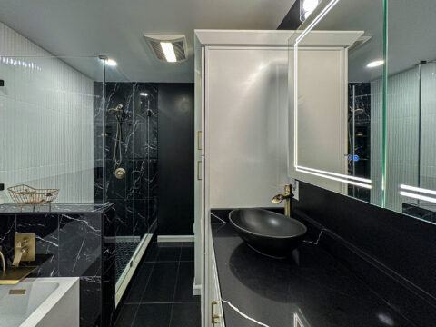 Luxury Bathroom Renovation with Black Quartz Countertops and Gold Hardware